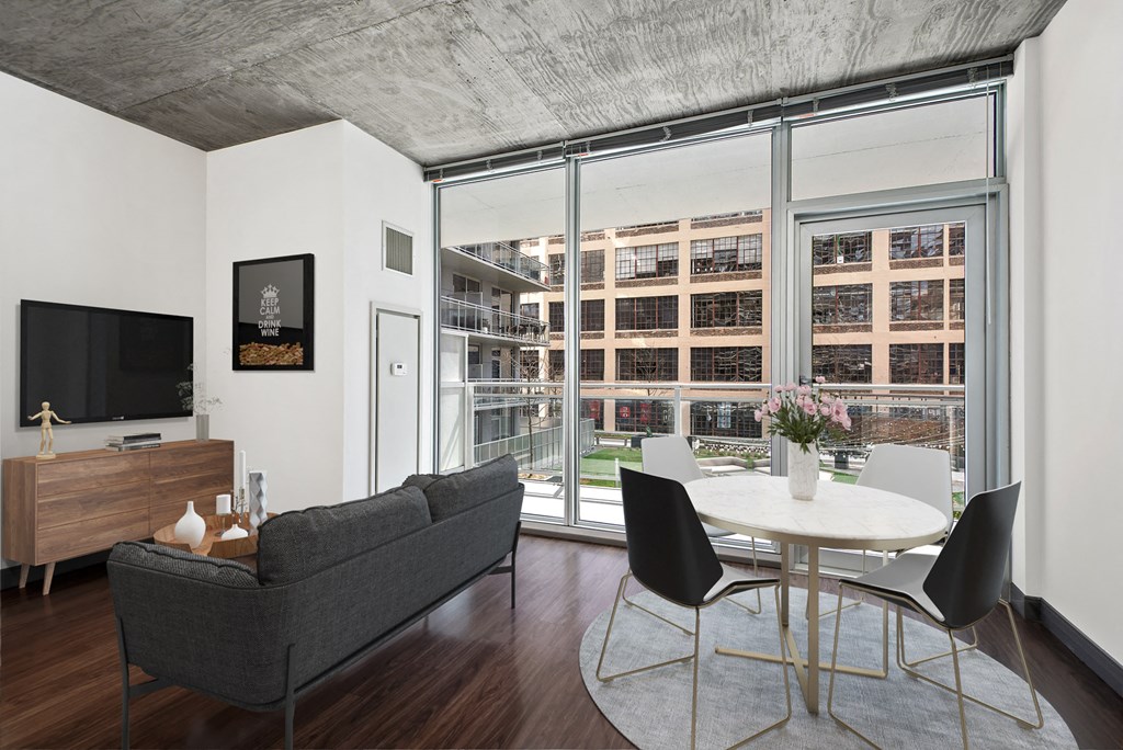 a living room with a large window and a table and chairs