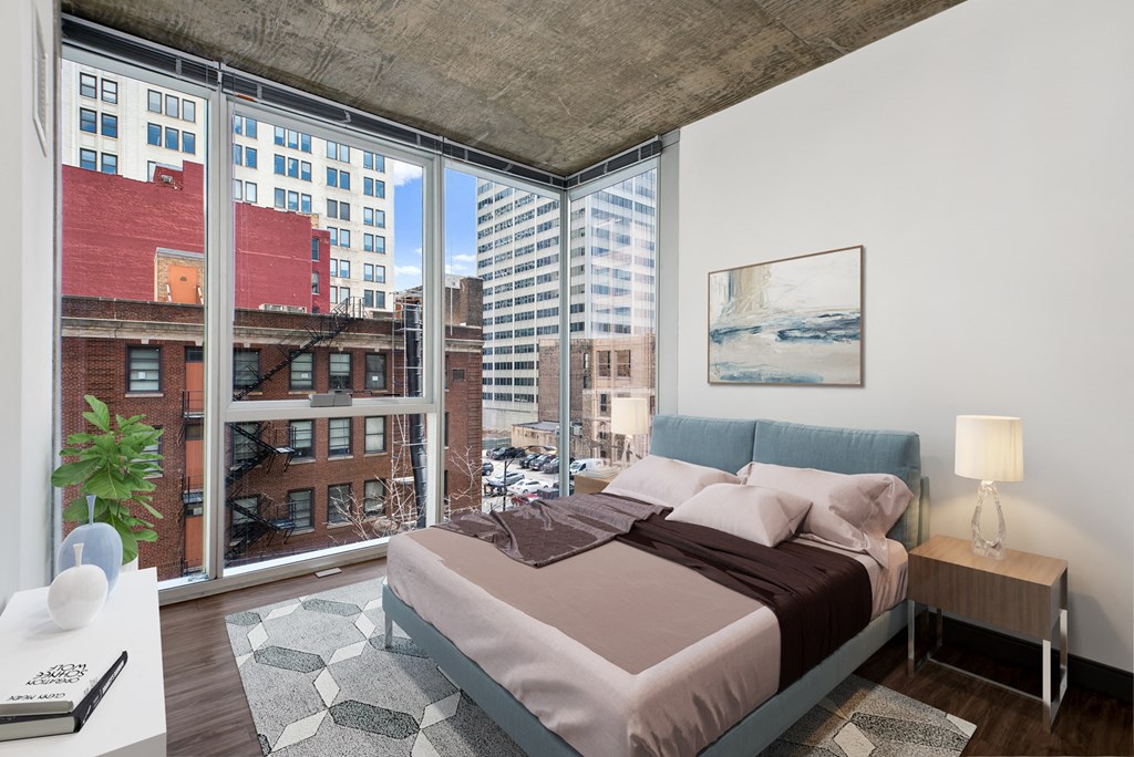 a bedroom with a large window and a bed in a room with a city view