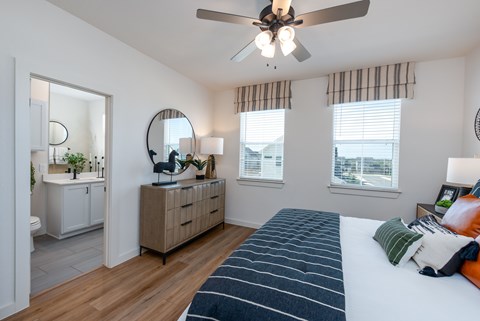 A bedroom with a large bed and a ceiling fan.