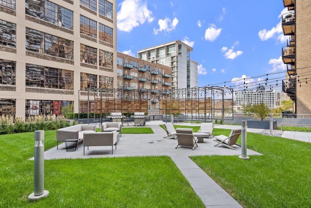 a courtyard with lawn chairs and tables in front of a building