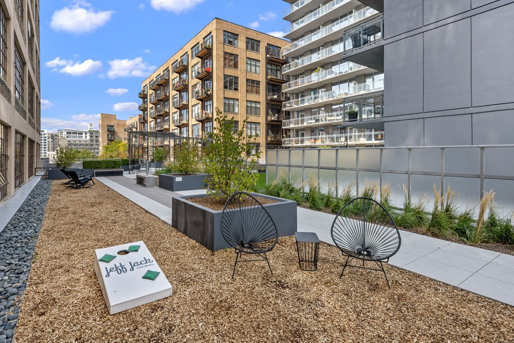 a patio with two chairs and a table in front of an apartment building
