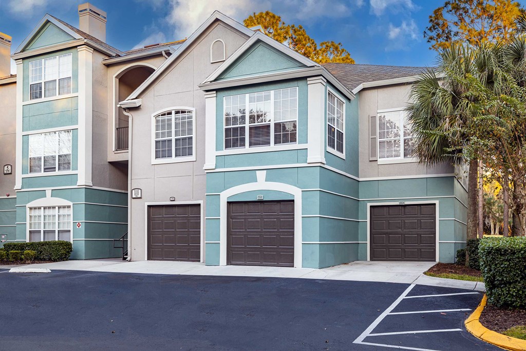 a blue and white house with two garage doors