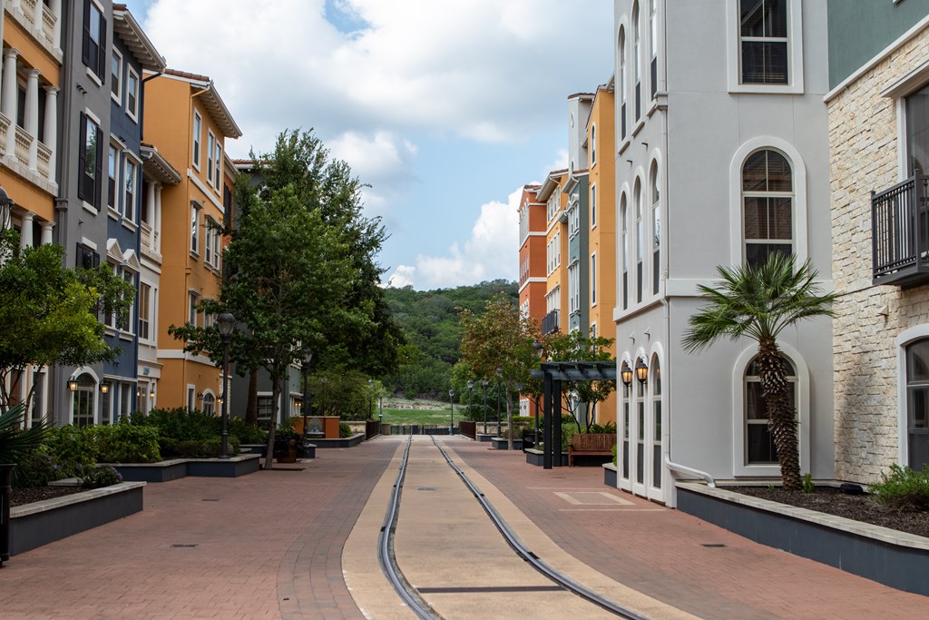a city street with buildings on both sides and a river in the distance