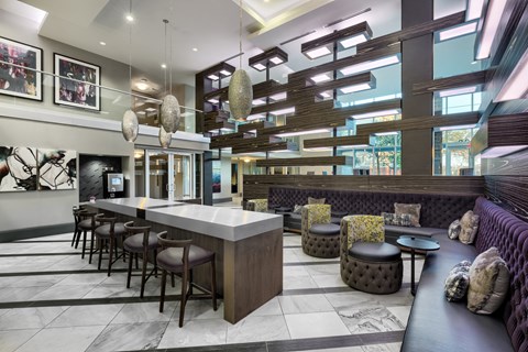 A modern bar area with a long counter and stools.