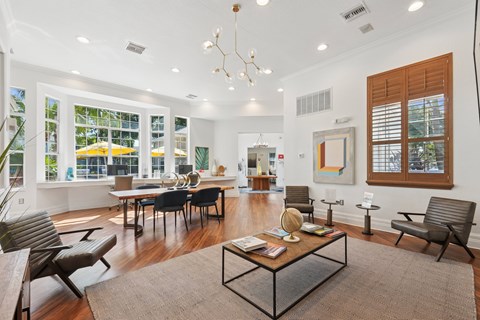 A modern living room with a glass table and black chairs.
