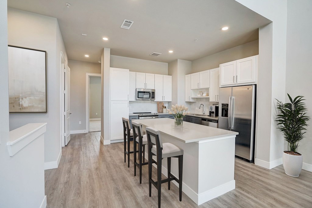 an open kitchen with a large island with chairs