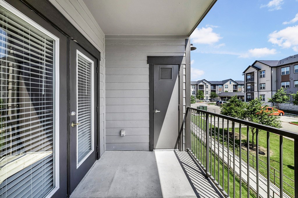 the view from the balcony of an apartment building with a door to the yard