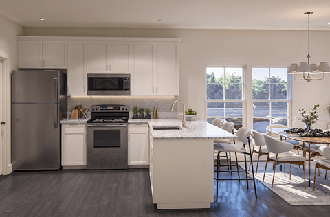 A modern kitchen with white cabinets and a large island.