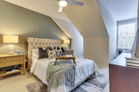 A bedroom with a large bed and a wooden nightstand.