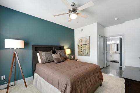 a bedroom with a bed and a ceiling fan