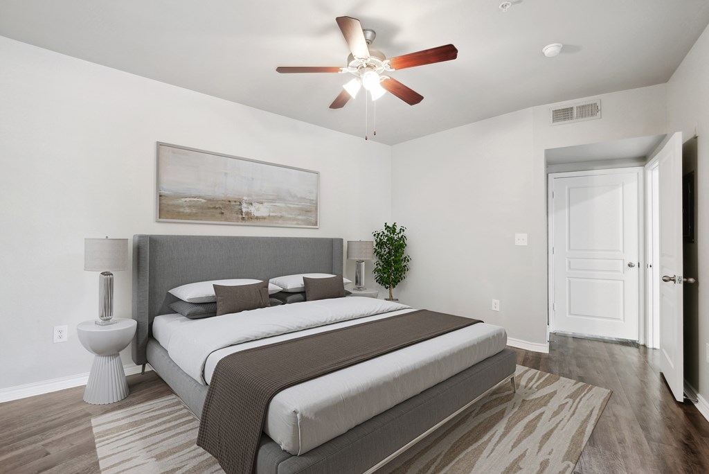 a bedroom with a large bed and a ceiling fan