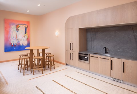 A kitchen with a table and chairs and a painting on the wall.