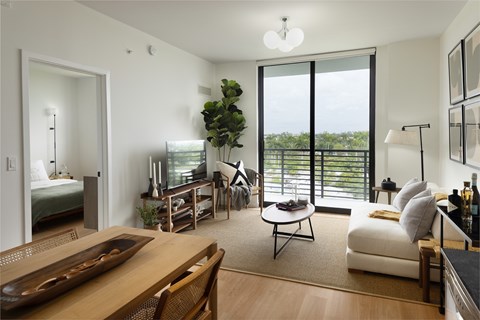 A living room with a wooden table and a white couch.