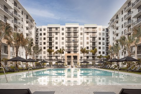A large swimming pool in front of apartment buildings.