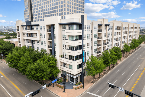 A modern apartment building with a parking lot in front.