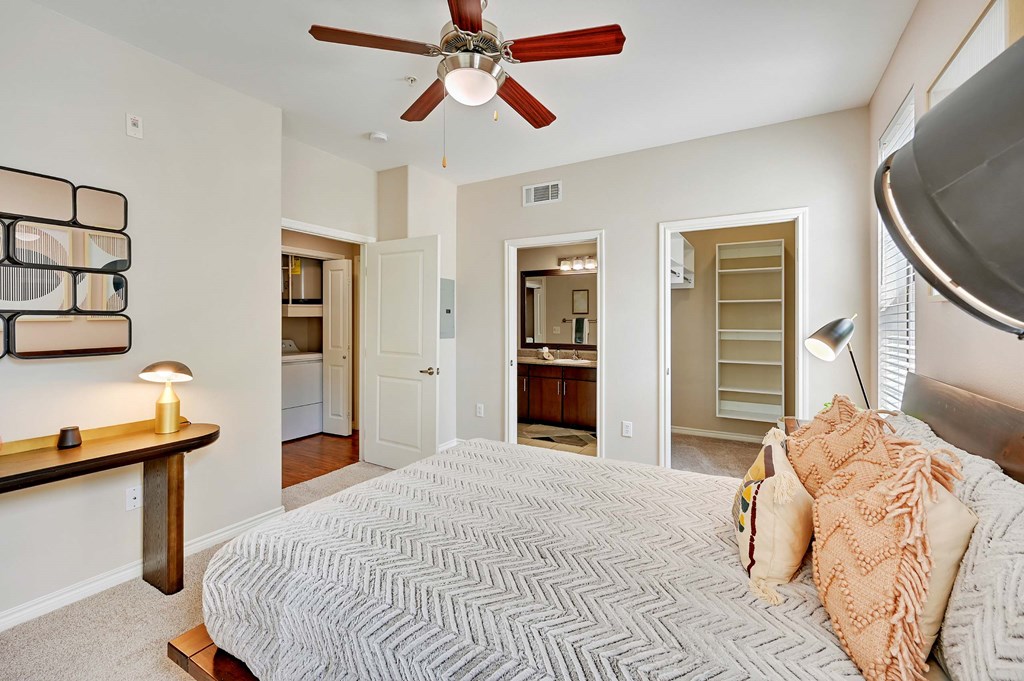 a bedroom with a large bed and a ceiling fan