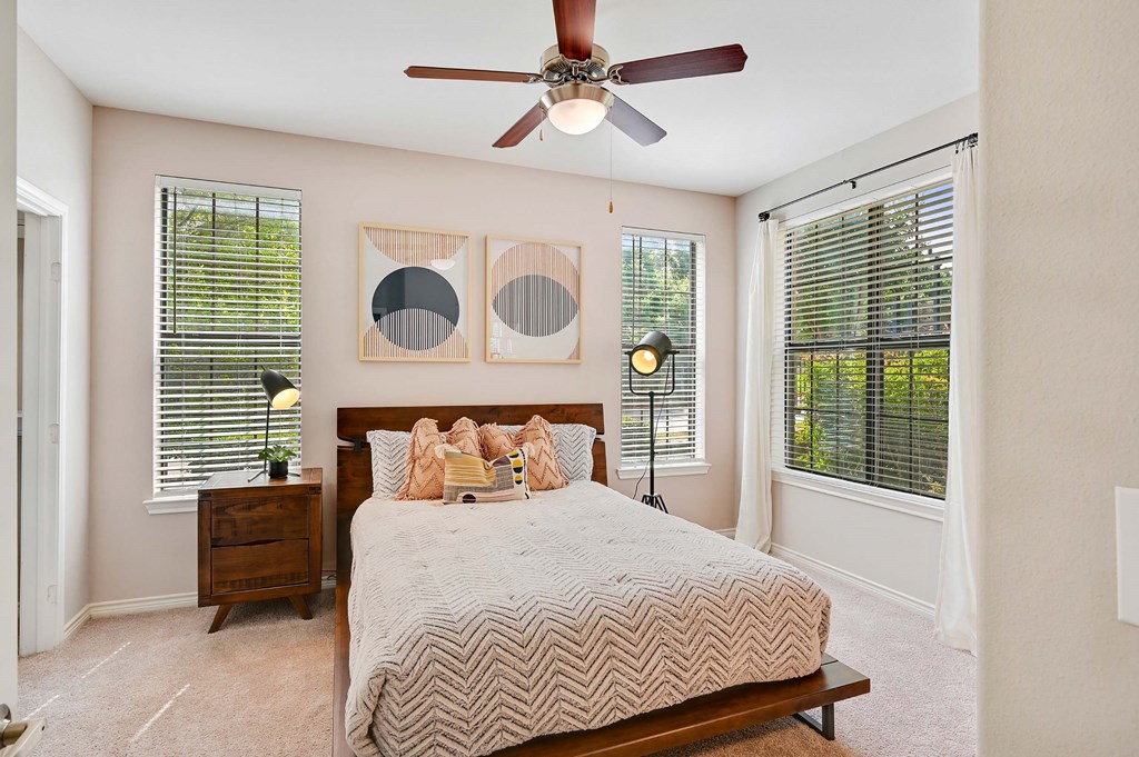 a bedroom with a large bed and a ceiling fan