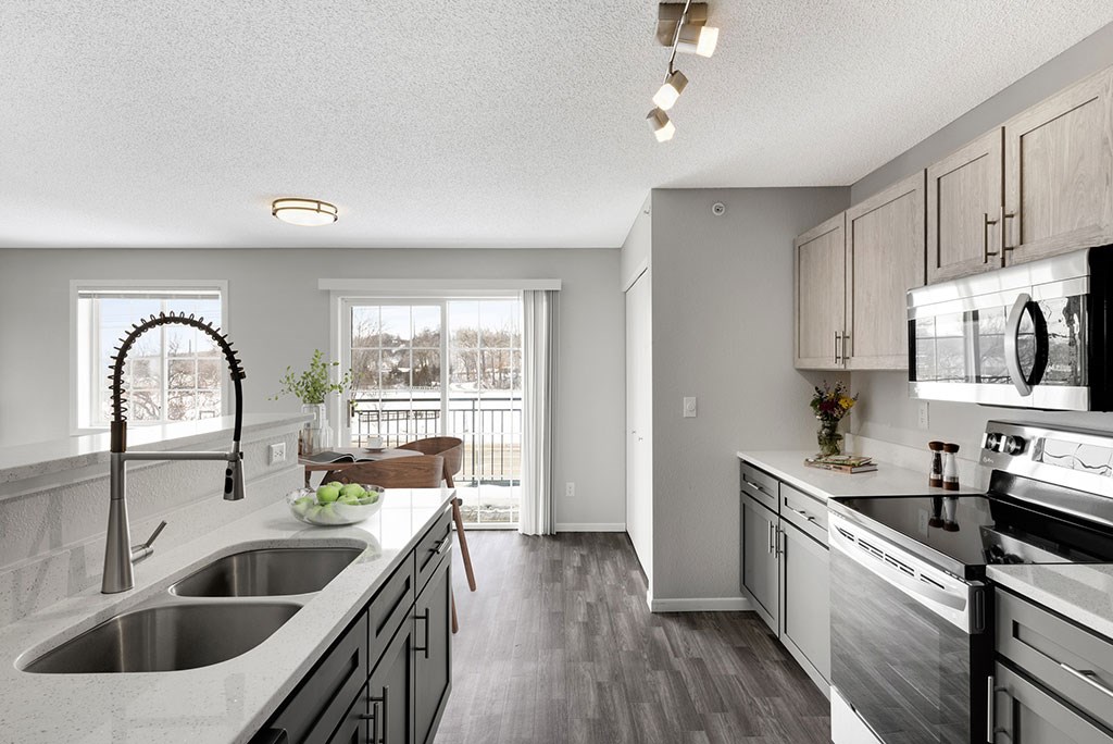 an open kitchen with stainless steel appliances and white cabinets