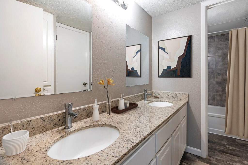 a bathroom with two sinks and a walk in shower