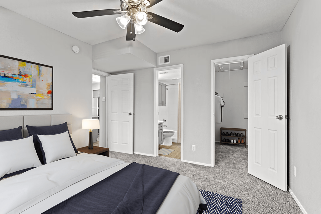 a bedroom with a bed and a ceiling fan