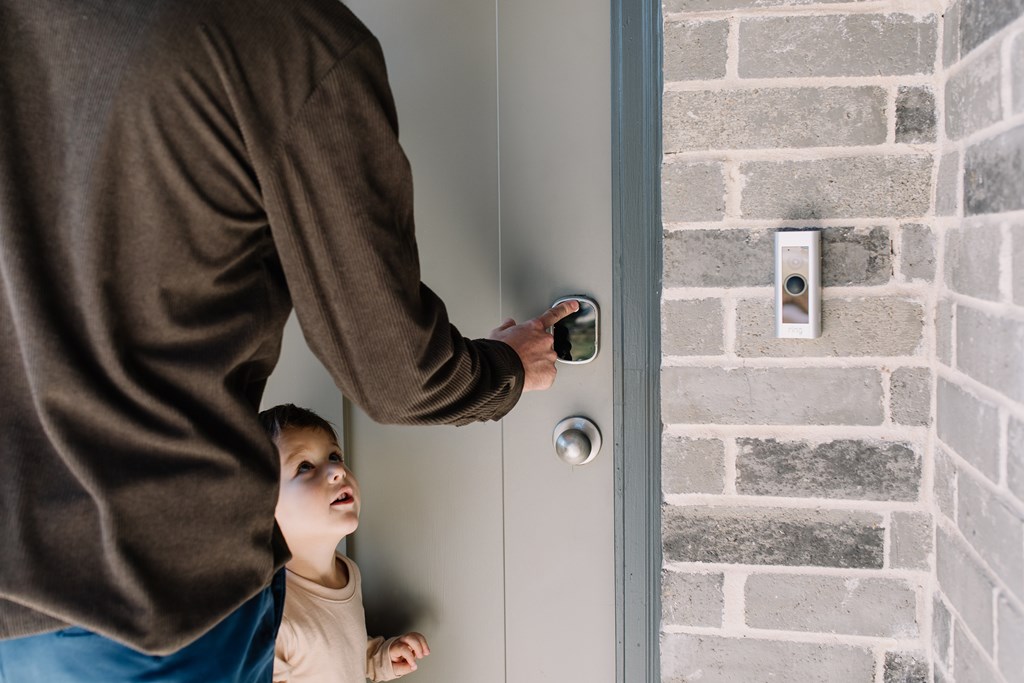 a man is knocking on a door with a child looking up at him