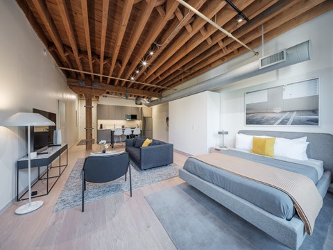 A modern bedroom with a large bed and a living area.
