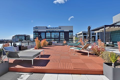 A rooftop patio with a table and chairs.