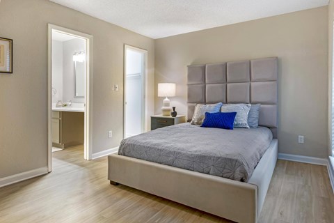 A bedroom with a large bed and a dresser with a mirror.