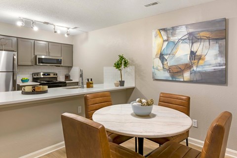 A modern kitchen with a dining table and chairs.