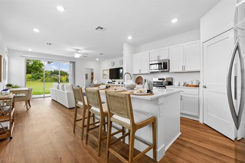 A modern kitchen with a dining table and chairs.
