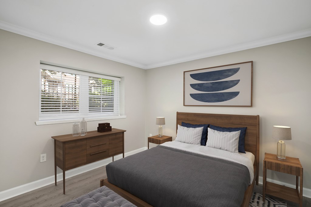 a bedroom with a bed and two dressers and a window