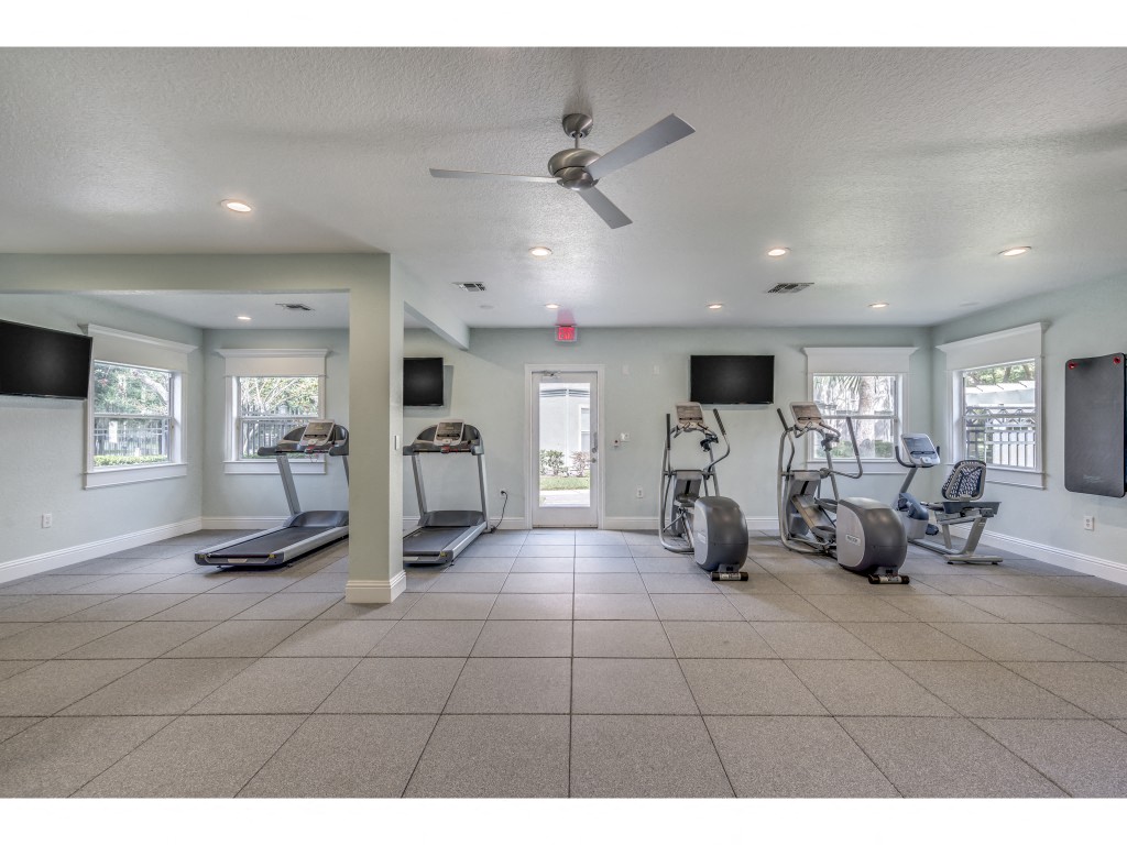 a workout room with weights and a ceiling fan