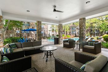 A patio with a table and chairs and a ceiling fan.