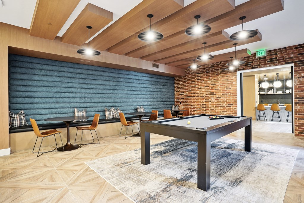 a game room with a pool table and a brick wall