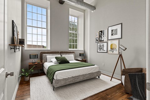A bedroom with a bed, nightstand, and a chair.