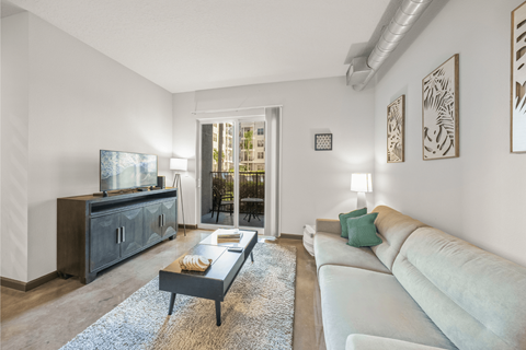 A living room with a white couch and a wooden cabinet.