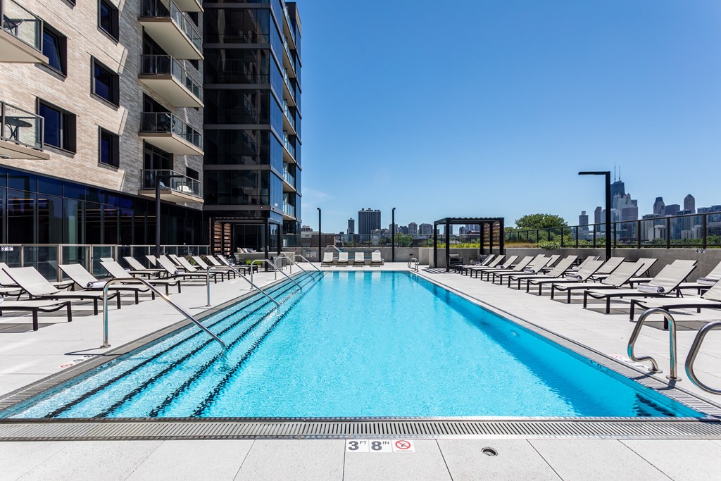 Pet-Friendly Apartments In Old Town, Chicago, IL - North + Vine - Resort-Style Pool with Sundeck, Chaise Lounge Chairs, and Views of the City.
