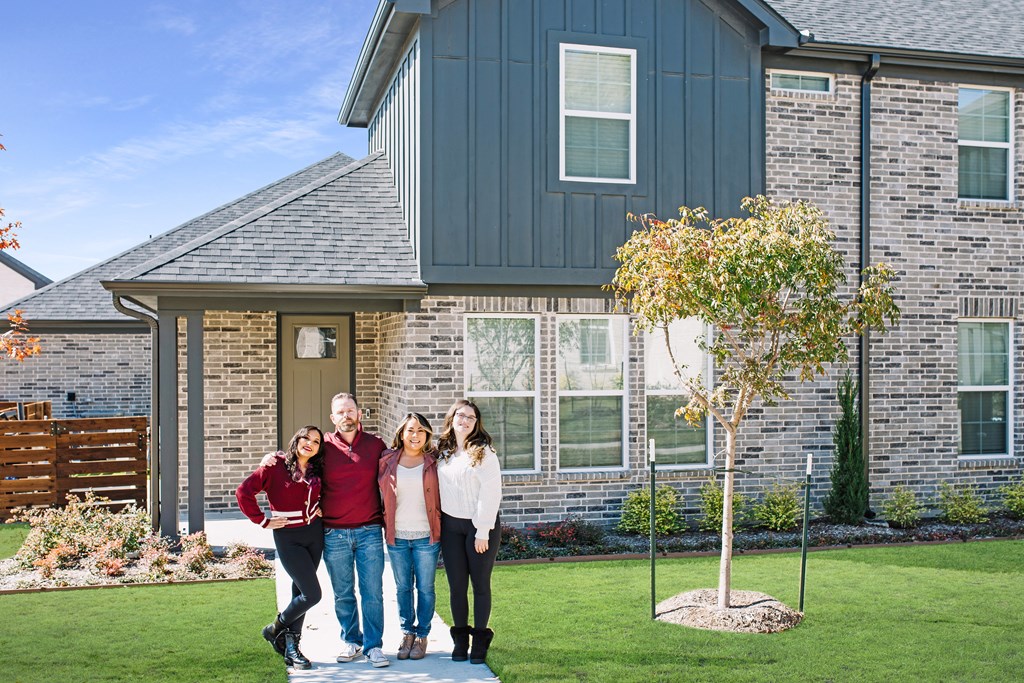 a family poses in front of a house