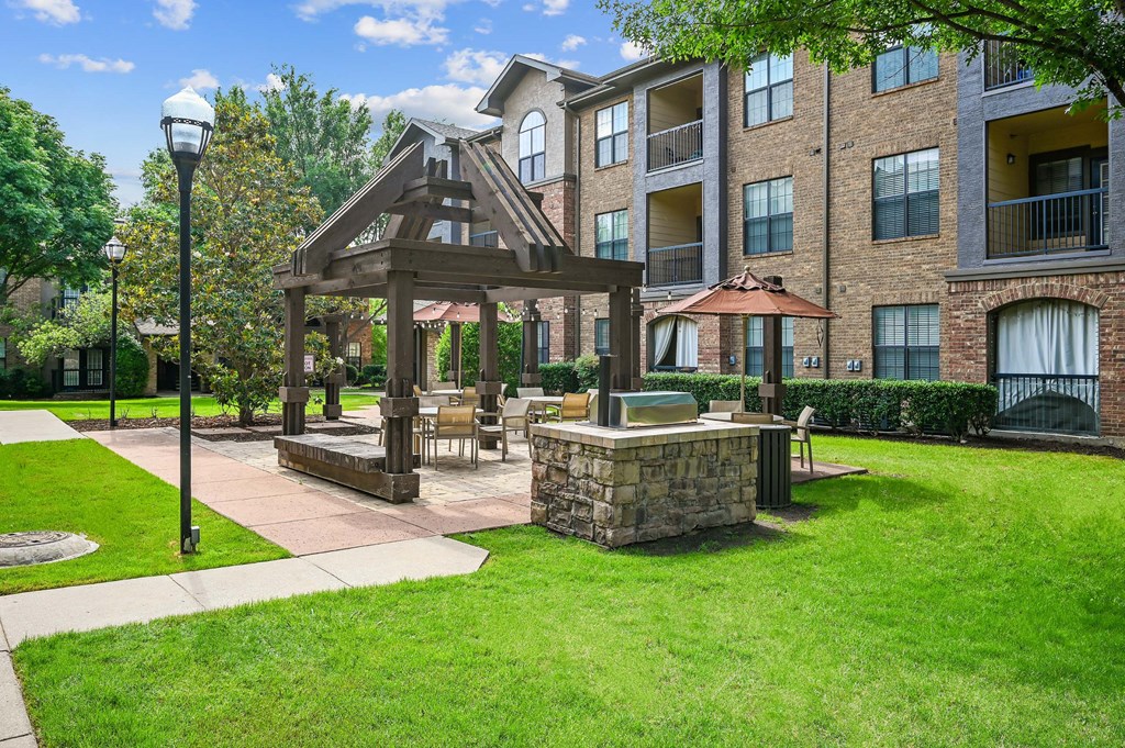 a patio with a gazebo in front of an apartment building