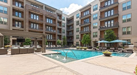 A large swimming pool in front of apartment buildings.