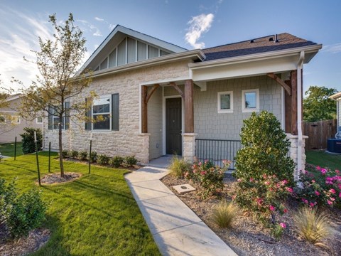 A house with a front yard and a tree.