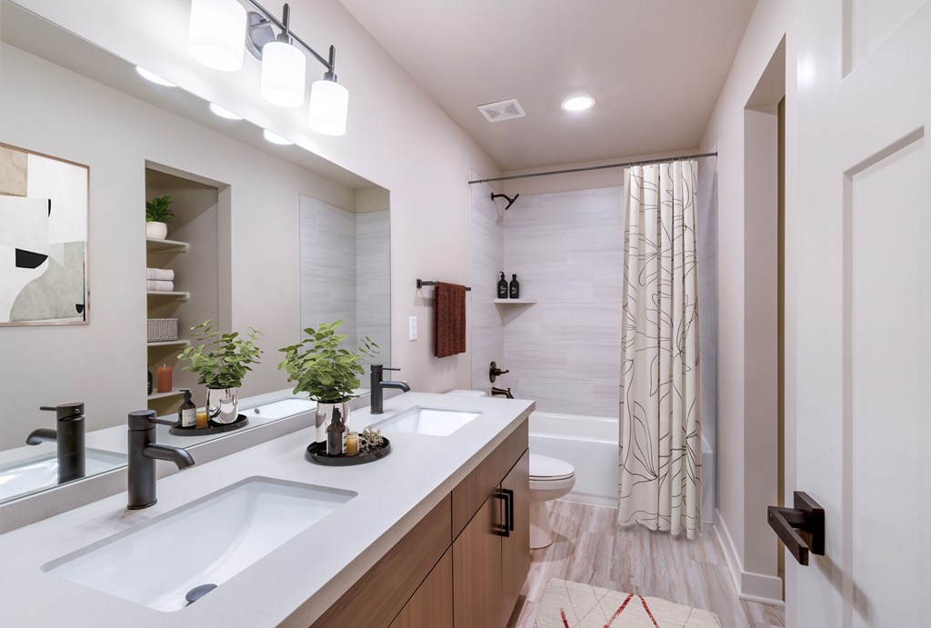 Pet-Friendly Apartments In Raymore, MO - Bathroom With Designer LVT Floors, Large Garden Soaking Shower, Large Mirror, Custom Vanity Cabinets, And Upgraded Plumbing Fixtures.