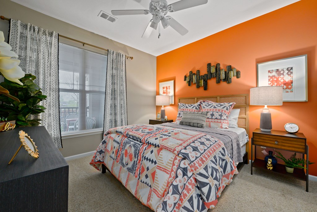 Riverstone - Bedroom with Orange Accent Wall, Side Tables, Lamps, and Decor