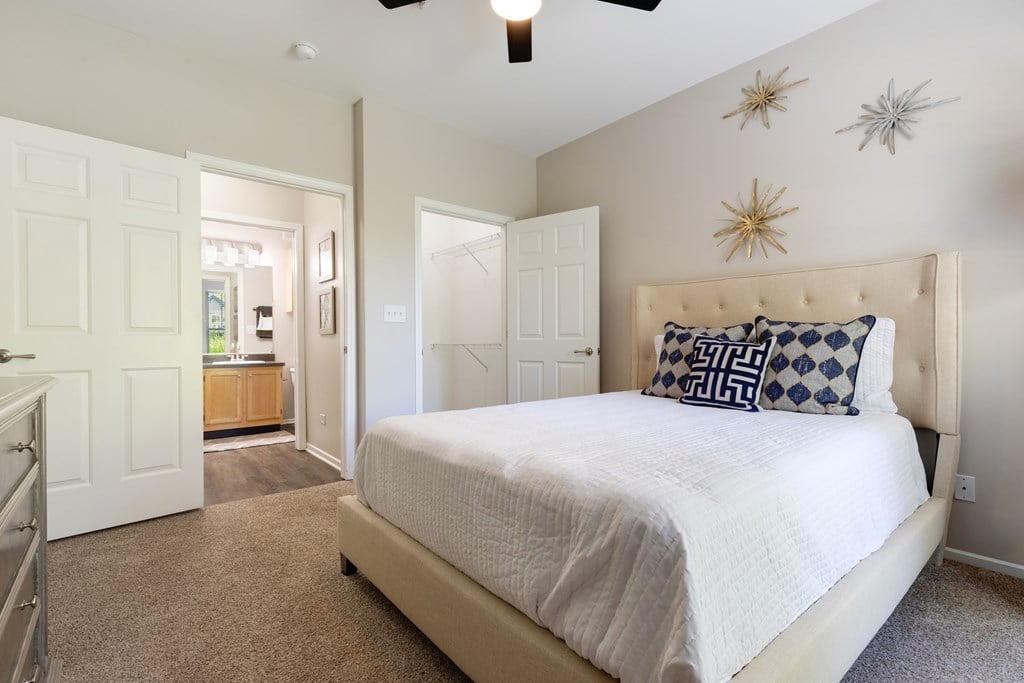 Three BR Apartments in Bolingbrook IL - The Meadows at River Run - Bedroom with Bed, Attached Bathroom, Sizable Closet, and Carpeted Floor
