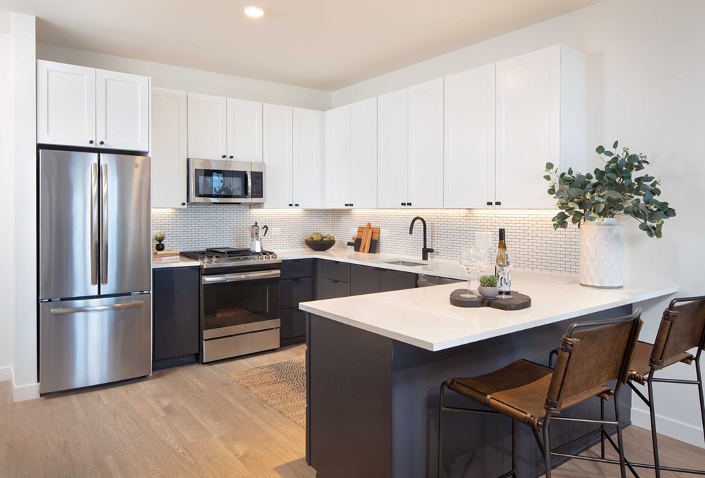 Old Town Apartments - North + Vine - Gourmet Kitchen with Subway Tile Backsplash, White Cabinets, White Countertops, and Appliances.
