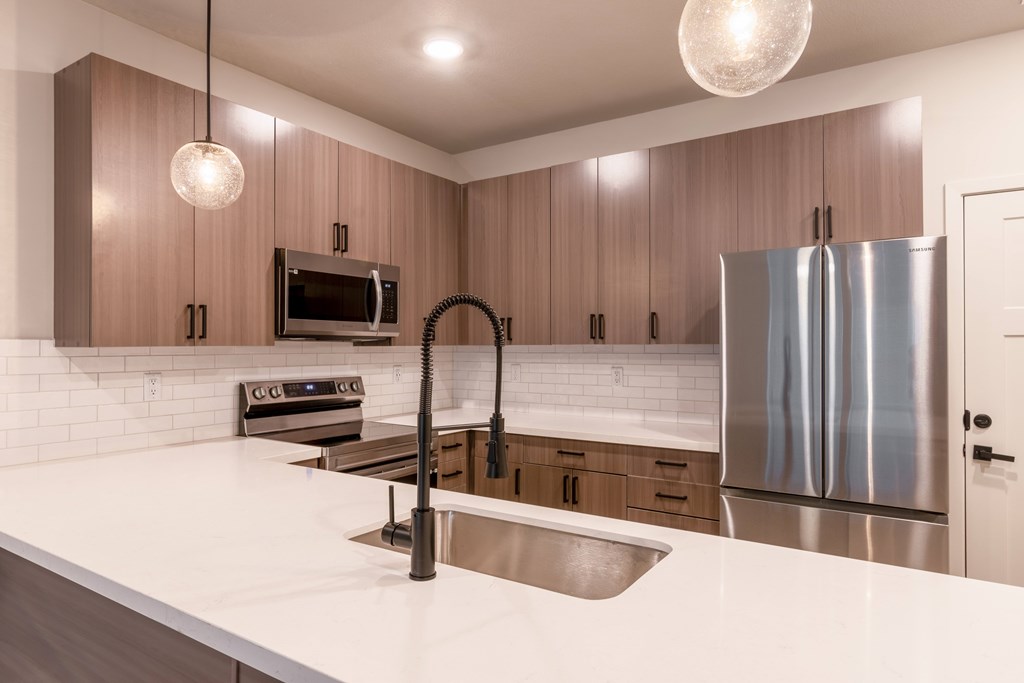 Townhouses For Rent In Raymore - Designer Kitchens With Island, Pantry, Quartz Countertops, Stainless Steel Samsung Appliances, Built-In Microwave, And Soft Close Cabinetry.