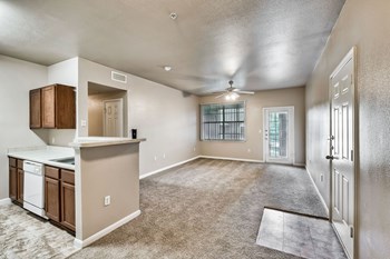 Apartment living room area with carpet and ceiling fan, open to kitchen - Photo Gallery 19