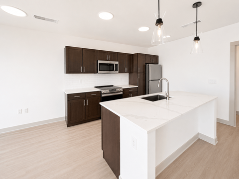 A kitchen with brown cabinets and a white island.