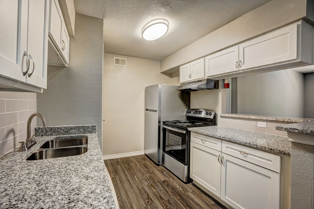 a kitchen with granite counter tops and stainless steel appliances