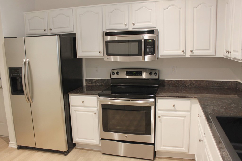 a kitchen with stainless steel appliances and white cabinets